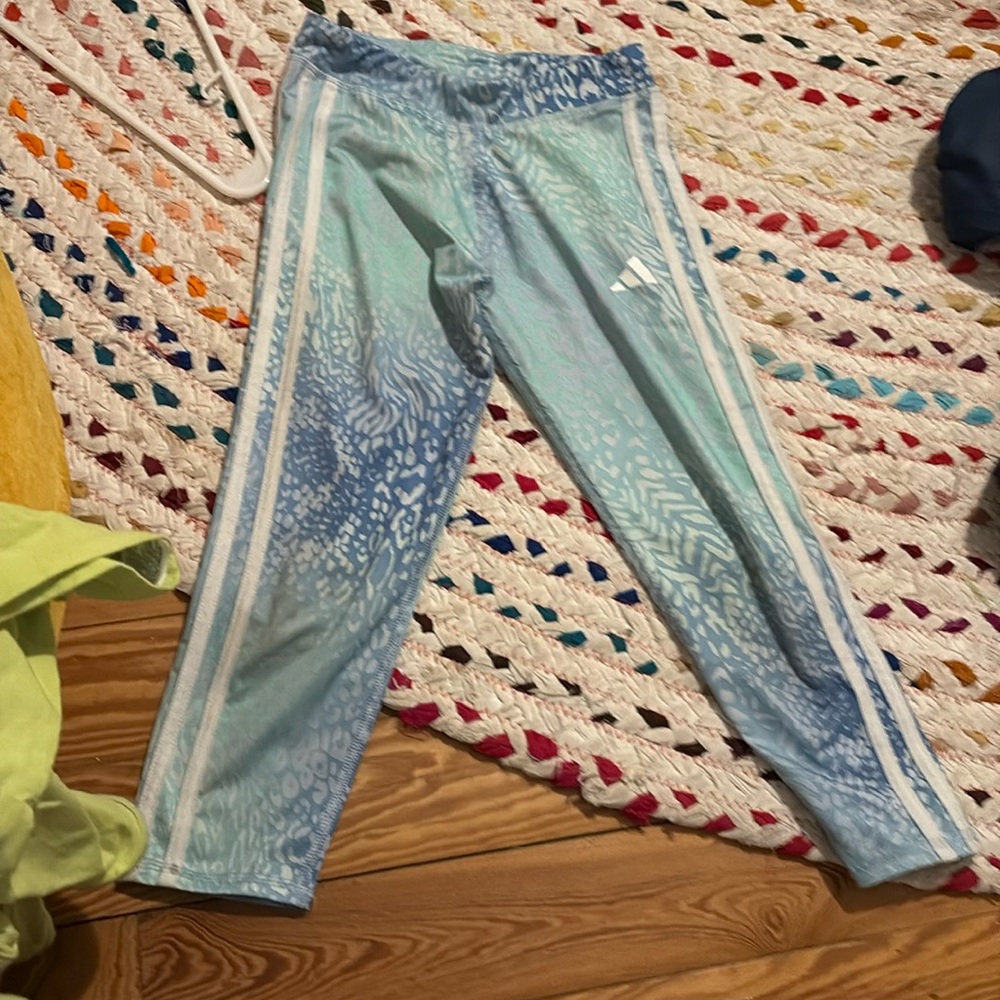 A blue teal and white pair of capris with the brand Adidas and athletic for girl